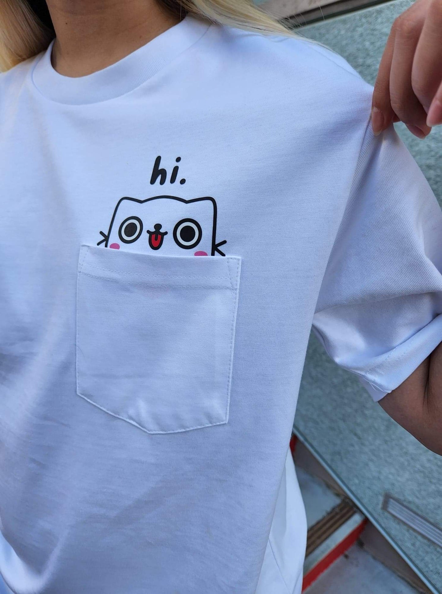 cat saying hi on a white pocket shirt