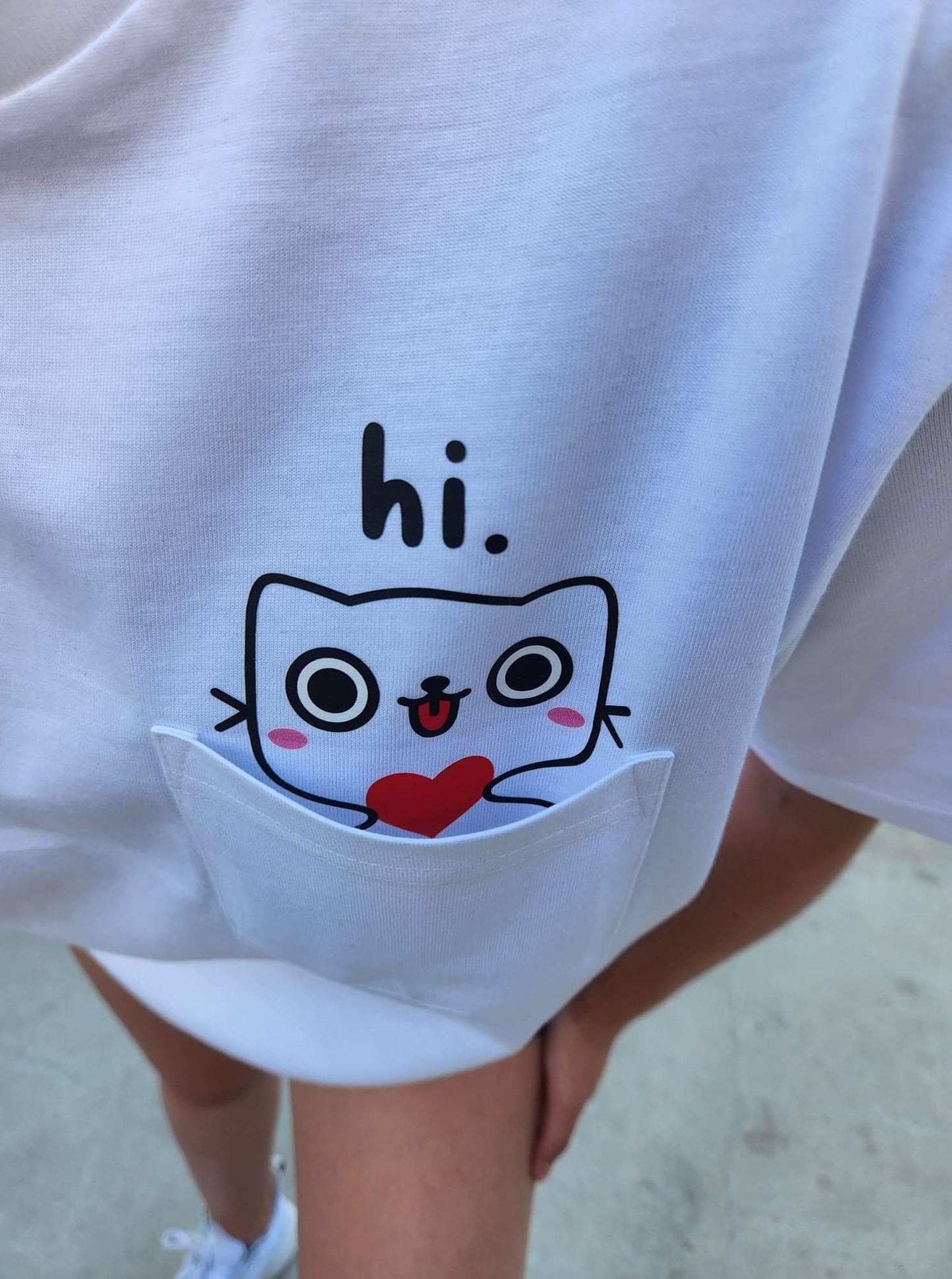 cat saying hi on a white pocket shirt